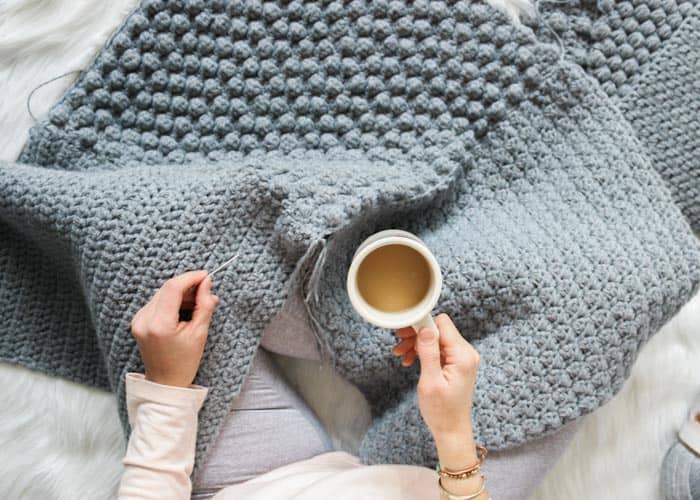 A crochet hygge scene with coffee, beautiful crochet stitches and a free crochet pattern in action.