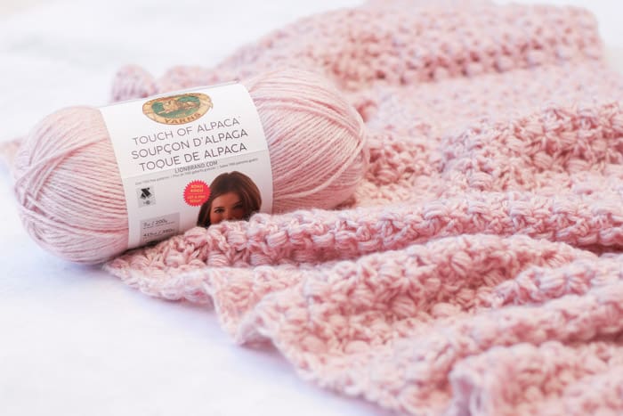 The At First Blush triangle scarf is an easy lace crochet shawl pattern, free from Make and Do Crew featuring Lion Brand Touch of Alpaca yarn in the color "blush."