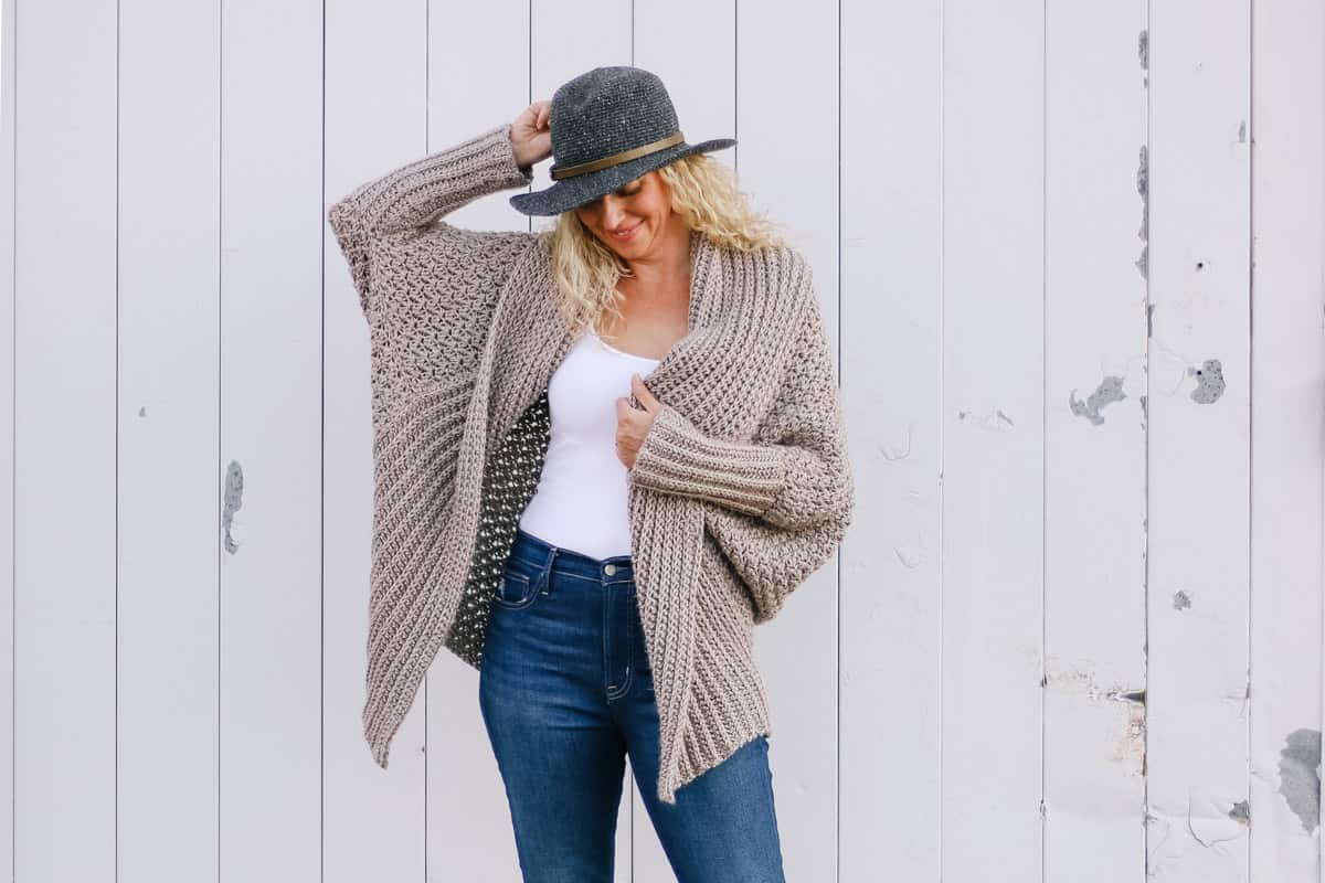 A woman wearing a soft, flowing crochet cardigan made with Lion Brand Heartland yarn in the color "Grand Canyon."