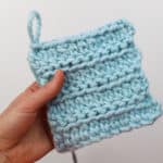 A swatch of Wool Ease Thick & Quick in "Glacier" crocheted in a combination of extended half double crochet and slip stitches. The effect of this crocheting looks like knitting.