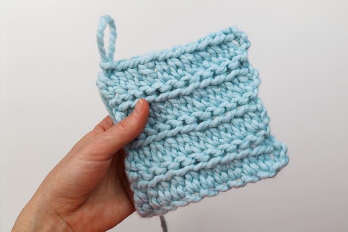 A swatch of Wool Ease Thick & Quick in "Glacier" crocheted in a combination of extended half double crochet and slip stitches. The effect of this crocheting looks like knitting.