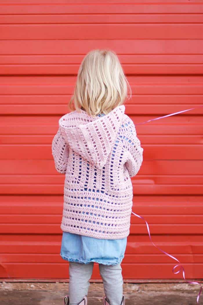 The back of a child's crochet cardigan jacket made from two hexagons. Free toddler sweater pattern designed by Jess Coppom of Make & Do Crew.