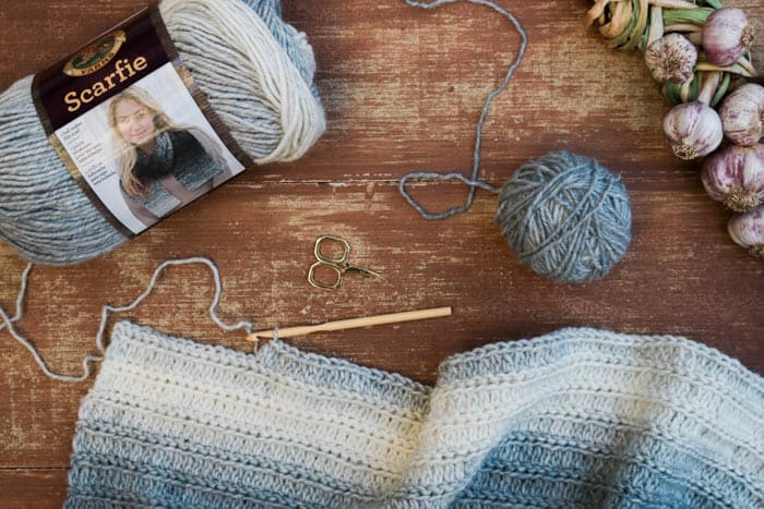 Lion Brand Scarfie yarn in Cream/Silver being crocheted into a free women's poncho pattern.