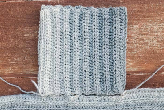 How to add a crochet collar to a poncho using half double crochet stitches. Lion Brand Scarfie in Cream/Silver yarn pictured.