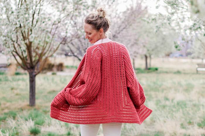 Easy crochet cardigan pattern made from two simple hexagons. This beginner-friendly free pattern and tutorial includes petite and plus sizes. Made with Lion Brand Yarn Vanna's Style in "Tomato."