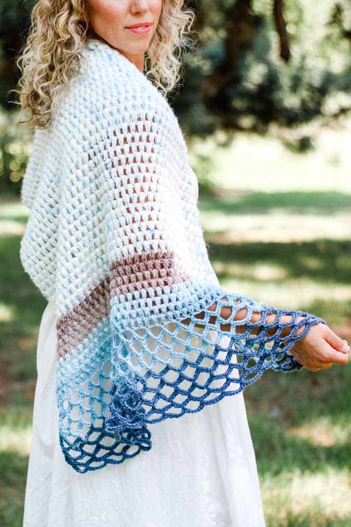 This elegant asymmetrical crochet triangle shawl pattern is simple to follow and fun to wear year round. Perfect for wearing to the beach, a summer wedding or even during the winter.