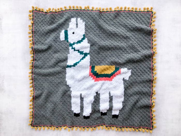 Flat lay of an Alpaca Love afghan corner-to-corner blanket on white background.