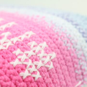 Close up of cross stitch on crochet fabric using Lion Brand Mandala Yarn.
