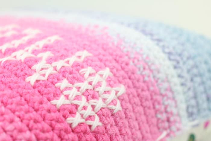 Close up of cross stitch on crochet fabric using Lion Brand Mandala Yarn.