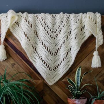 The intriguing repeat of basic stitches in this chunky crochet triangle scarf will hold the interest of beginning and more experienced crocheters alike. Perfect boho crochet scarf pattern for winter!