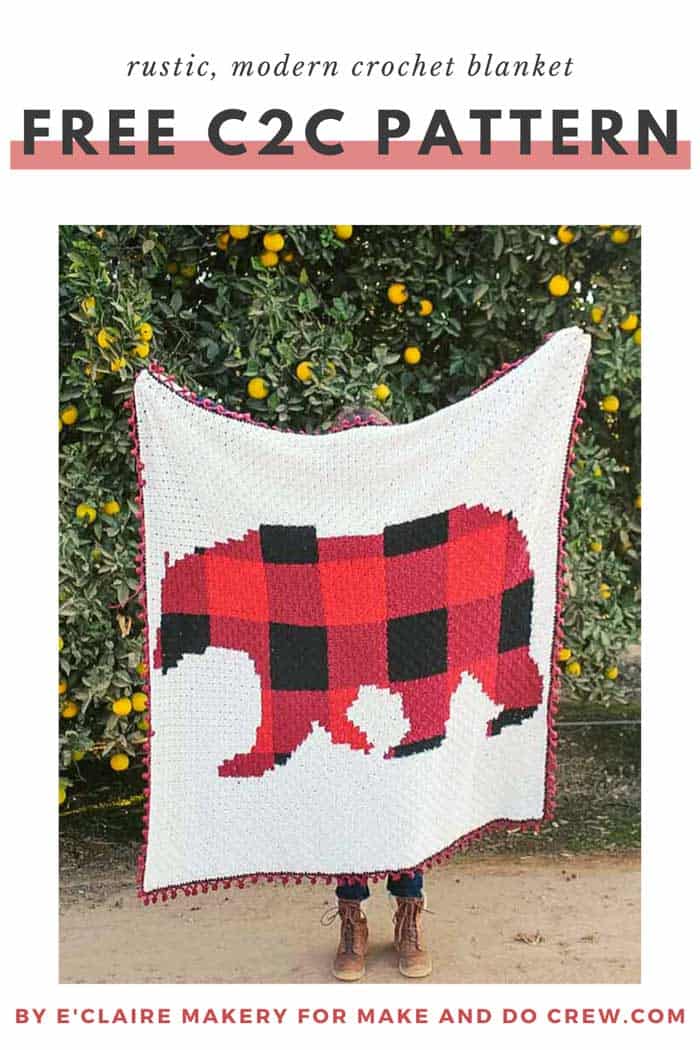 Woman holding a corner to corner crochet bear blanket made with red and black buffalo plaid with a pom pom border.