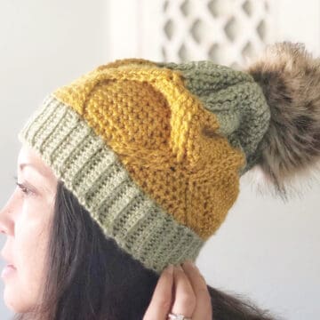 Woman wearing a pineapple-themed crochet hat with cables.