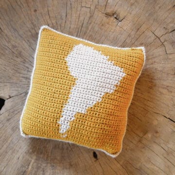 Crochet square pillow, on the front pillow square is a map outline of South America.