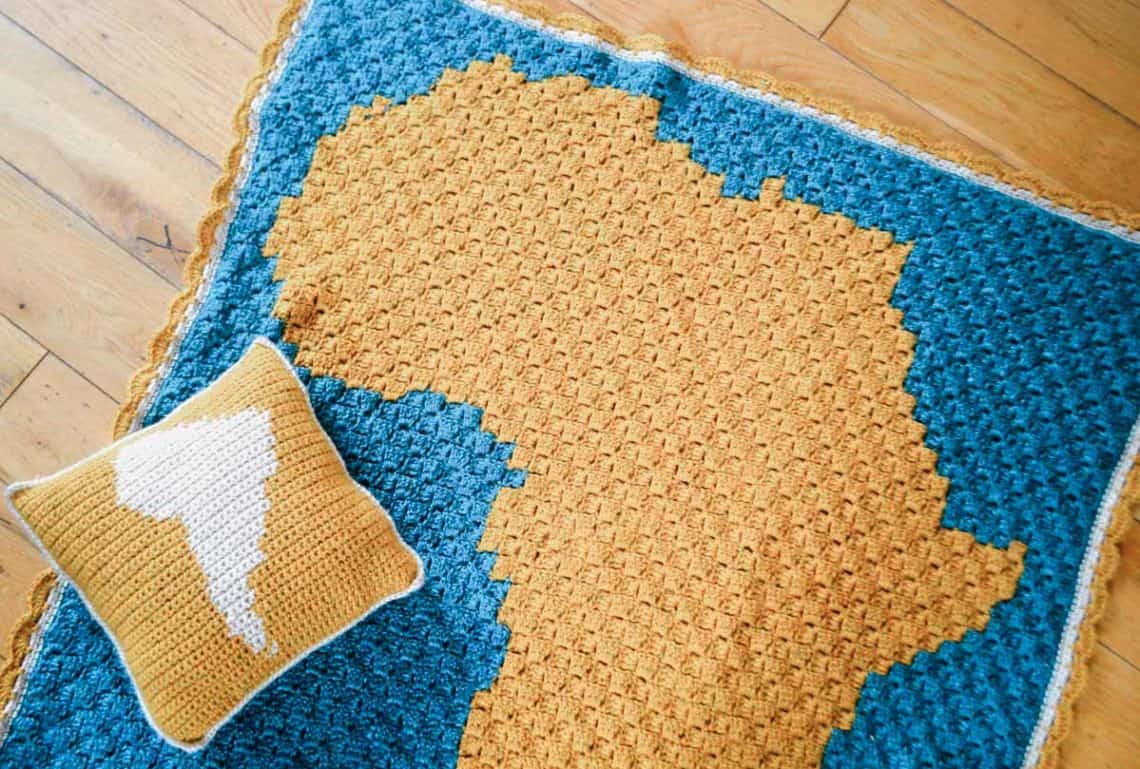 A corner to corner crochet blanket pattern with the silhouette of Africa on it.