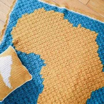 A corner to corner crochet blanket pattern with the silhouette of Africa on it.