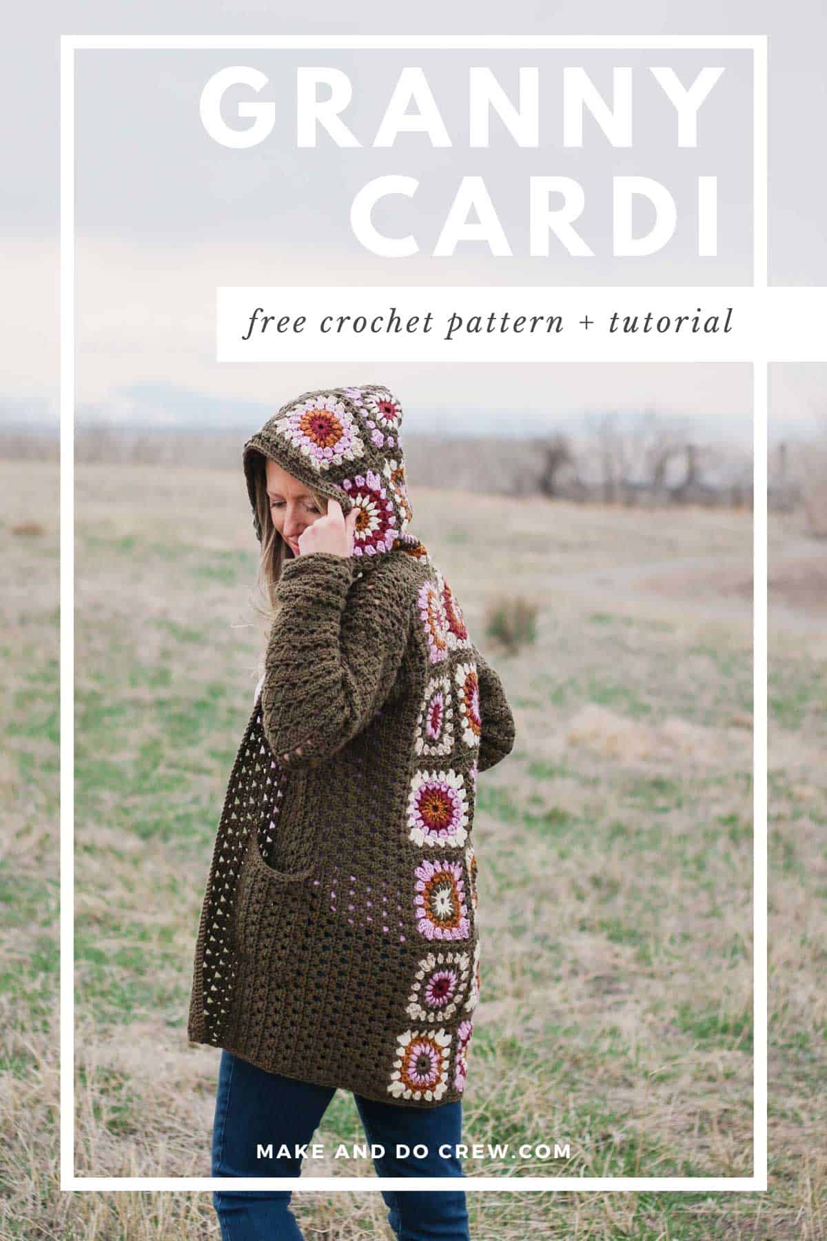 A woman looking down and wearing a modern crochet granny square cardigan while holding the hood and pocket of the cardigan.