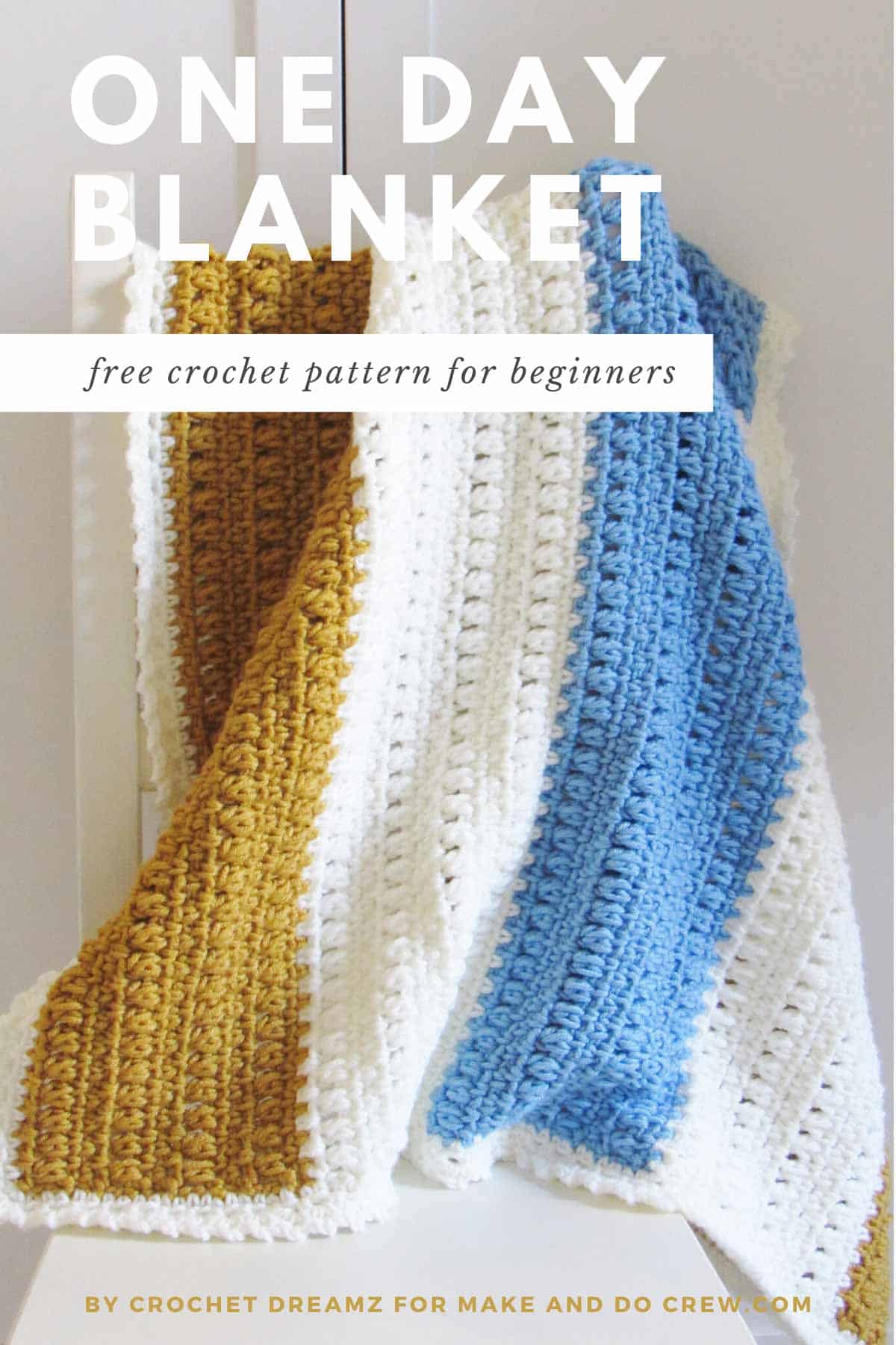 A wide gold, light blue, and white colored one-day crochet blanket pattern for beginners draped in a white chair.