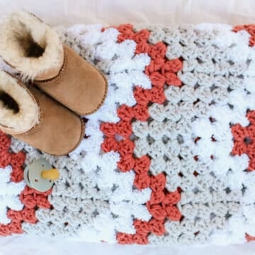Adorable baby sitting on a easy crochet baby blanket made from a free crochet pattern using Lion Brand yarn.
