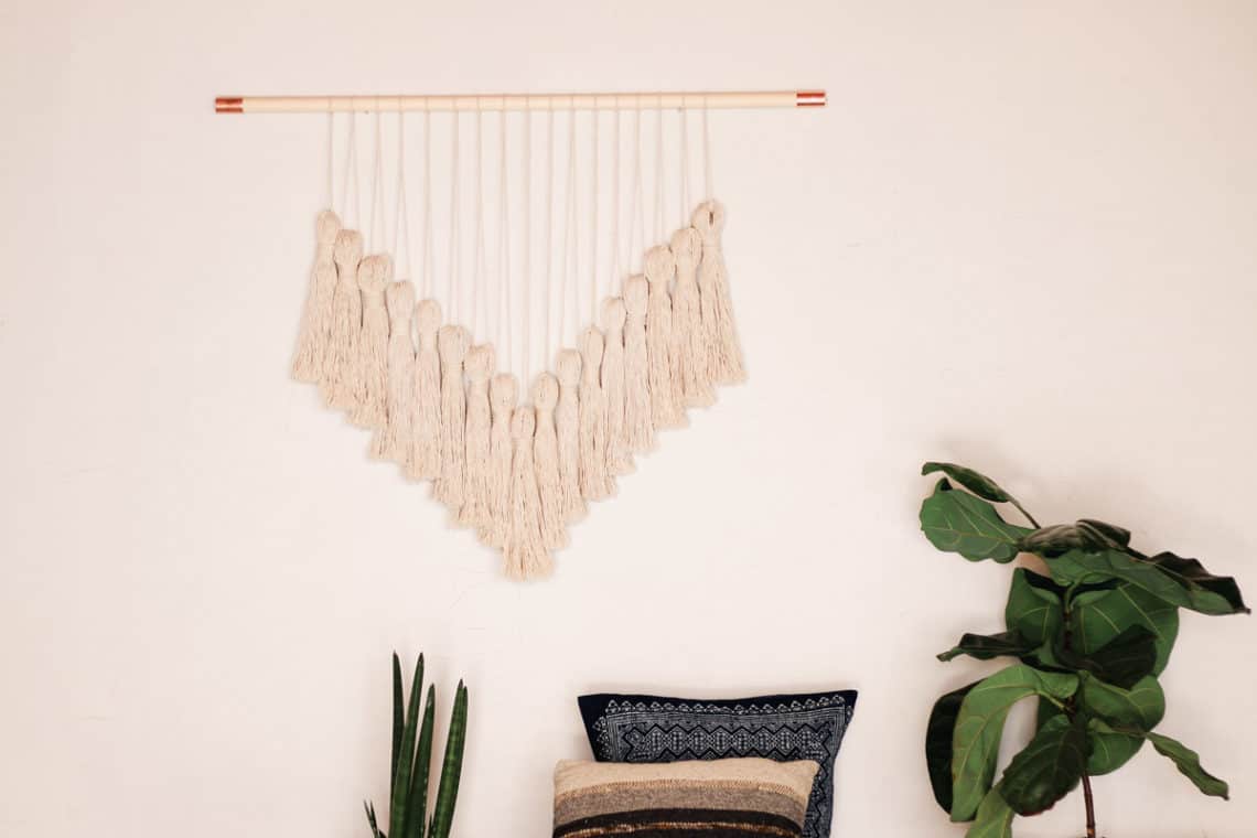 Affordable DIY Artwork for your boho home using yarn. The wall hanging uses copper pipe fittings to add a bit of glam.