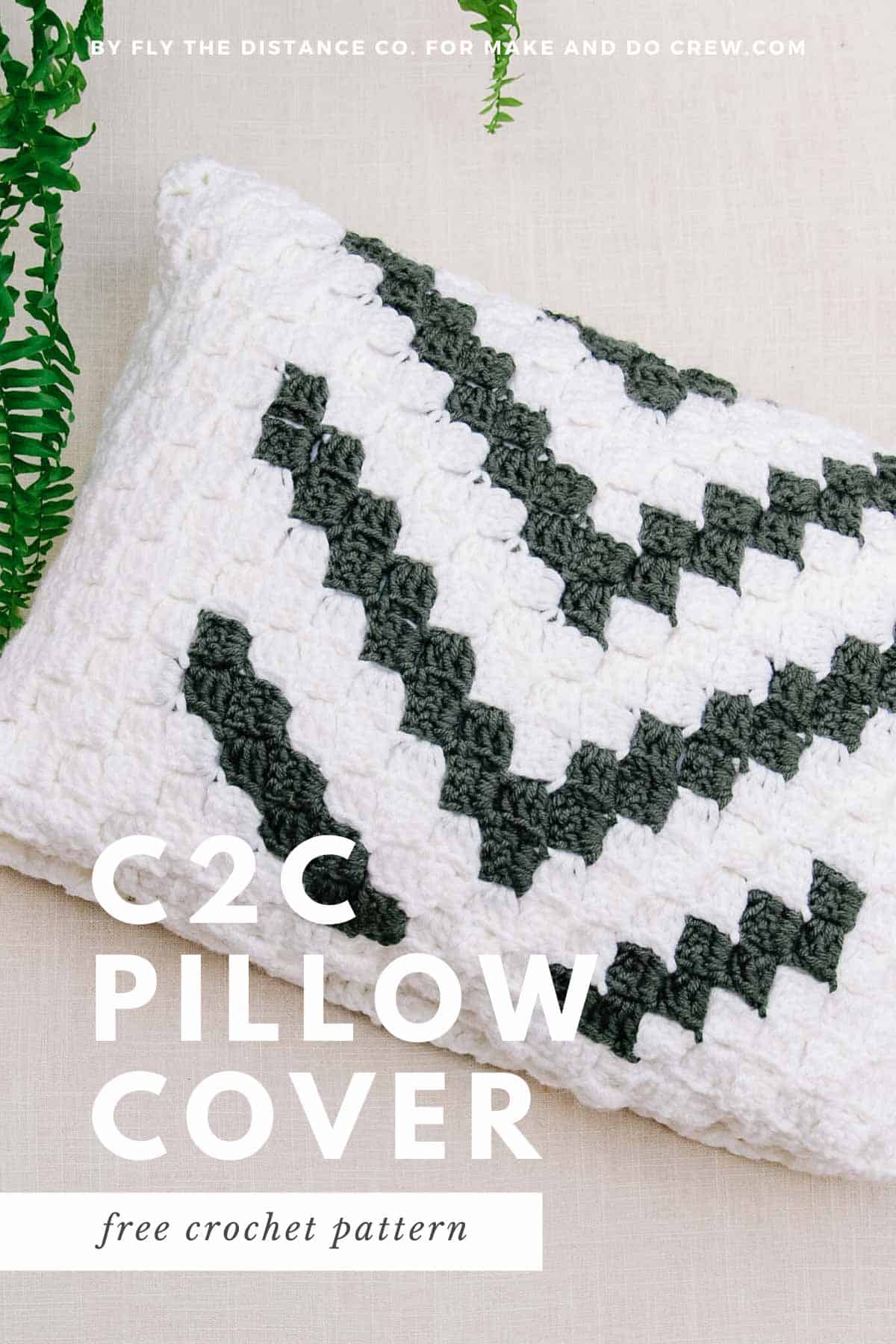 A graphic corner to corner crochet pillow made with off white and grey yarn.