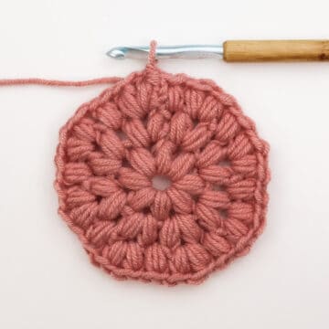 A crochet puff stitch circle coaster in progress.