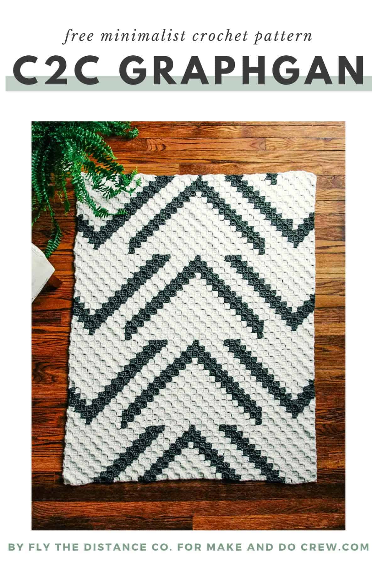 A modern c2c crochet blanket laying on a wood floor. The blanket has stylish pattern of arrows.