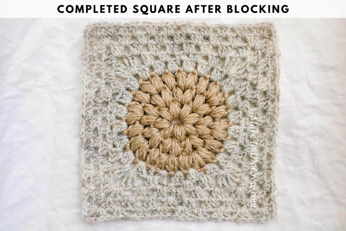 A finished modern crochet granny square made with a puff stitch circle in the center.