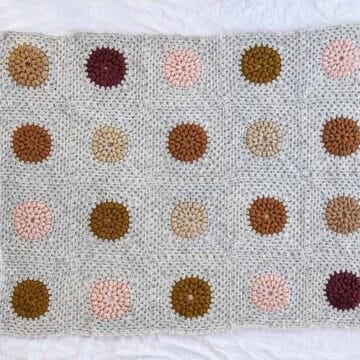 A crochet granny square blanket made from puff stitch circles.