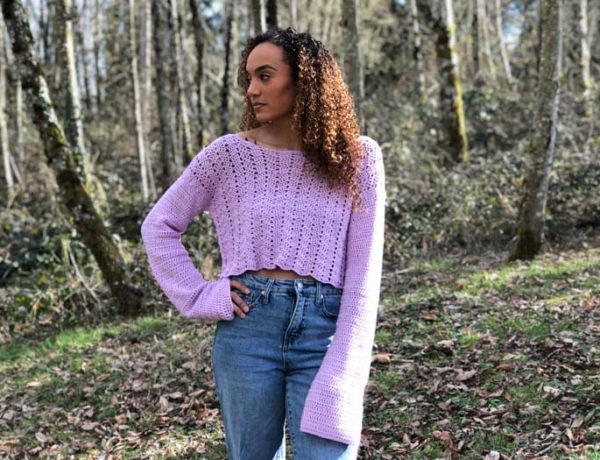 A lavender lacey crochet cropped sweater with bell sleeves.