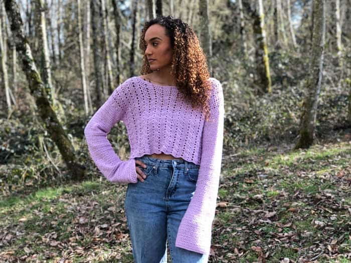 A lavender lacey crochet cropped sweater with bell sleeves.