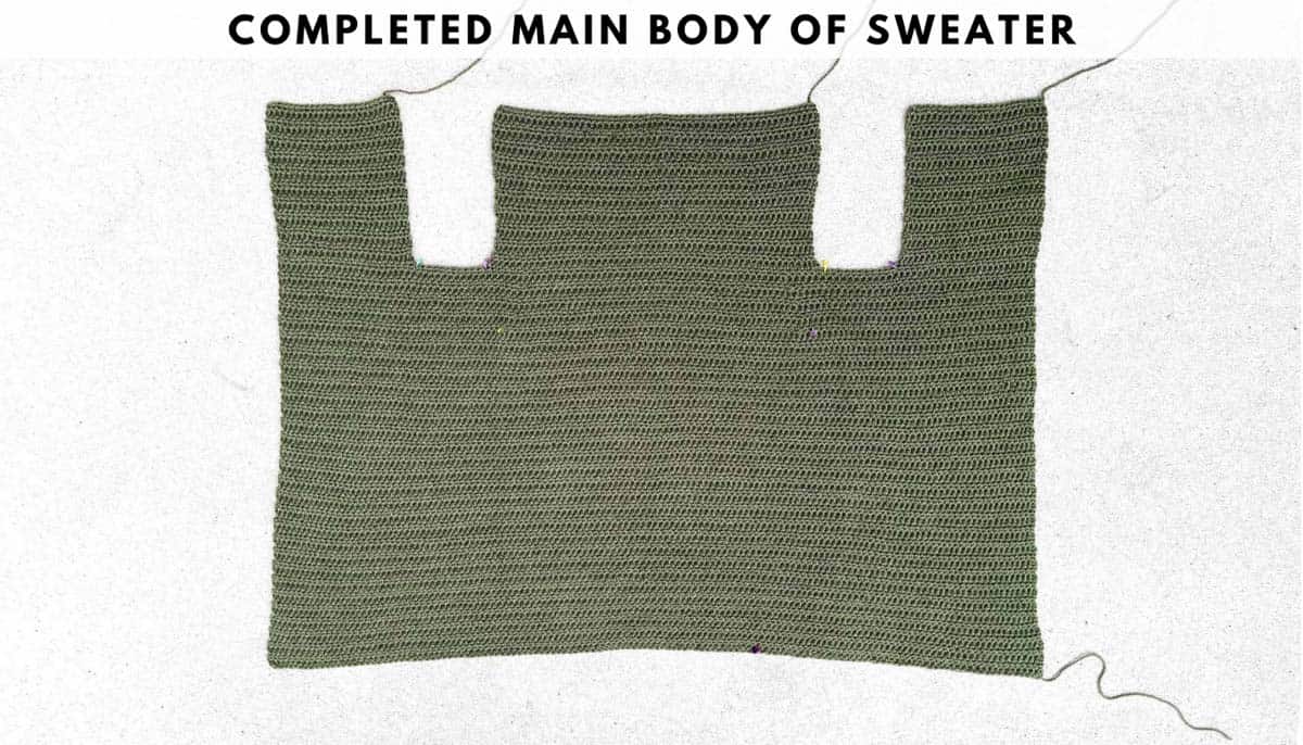An overhead shot of the completed main body of the olive green sweater on a white background.