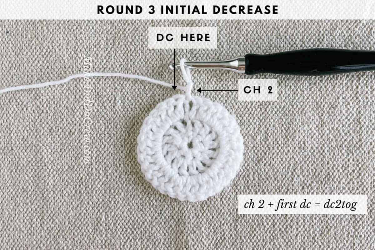 Crochet photo tutorial photo shows the initial decrease of round three while crocheting a star.