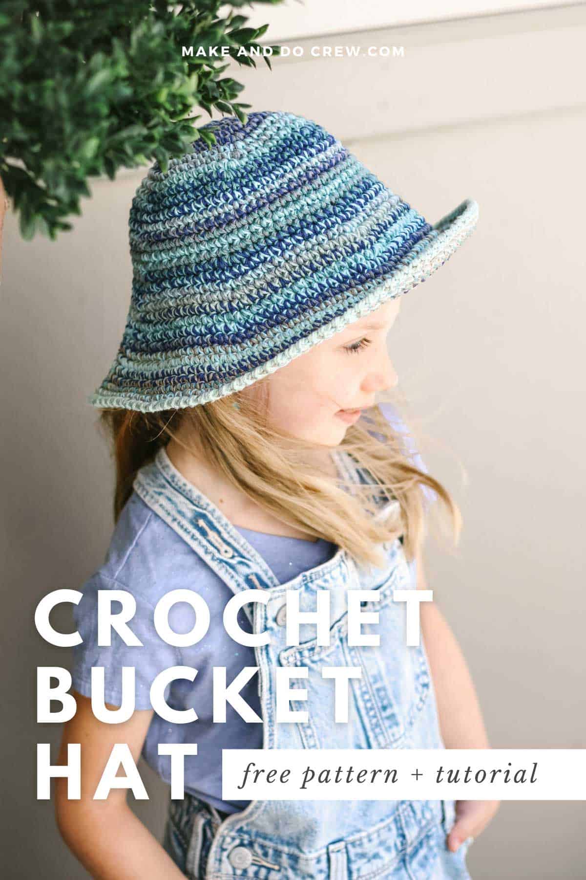This image shows a photo of a girl wearing a blue crochet bucket hat. She has blonde hair and is looking away from the camera with her hands in her pockets.