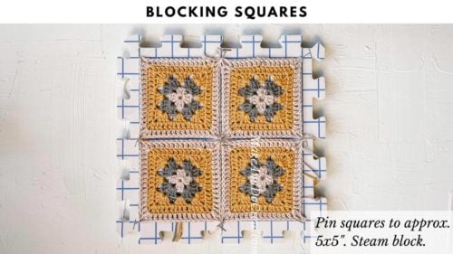 This image shows four crochet granny squares pinned down while being blocked.