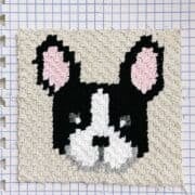 This image shows a corner to corner crochet square of a french bulldog or boston terrier. The c2c square is on a blocking board.