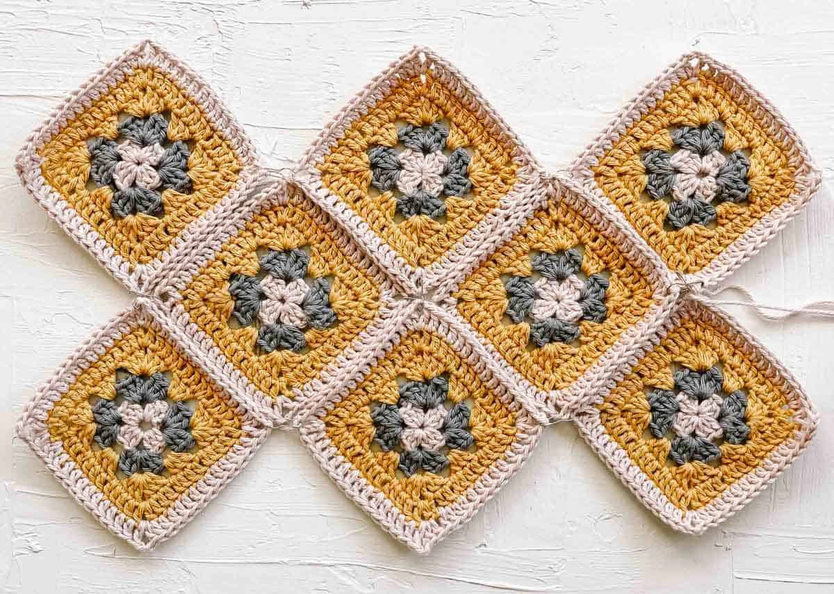 eight crochet granny squares laid out flat against a white background.
