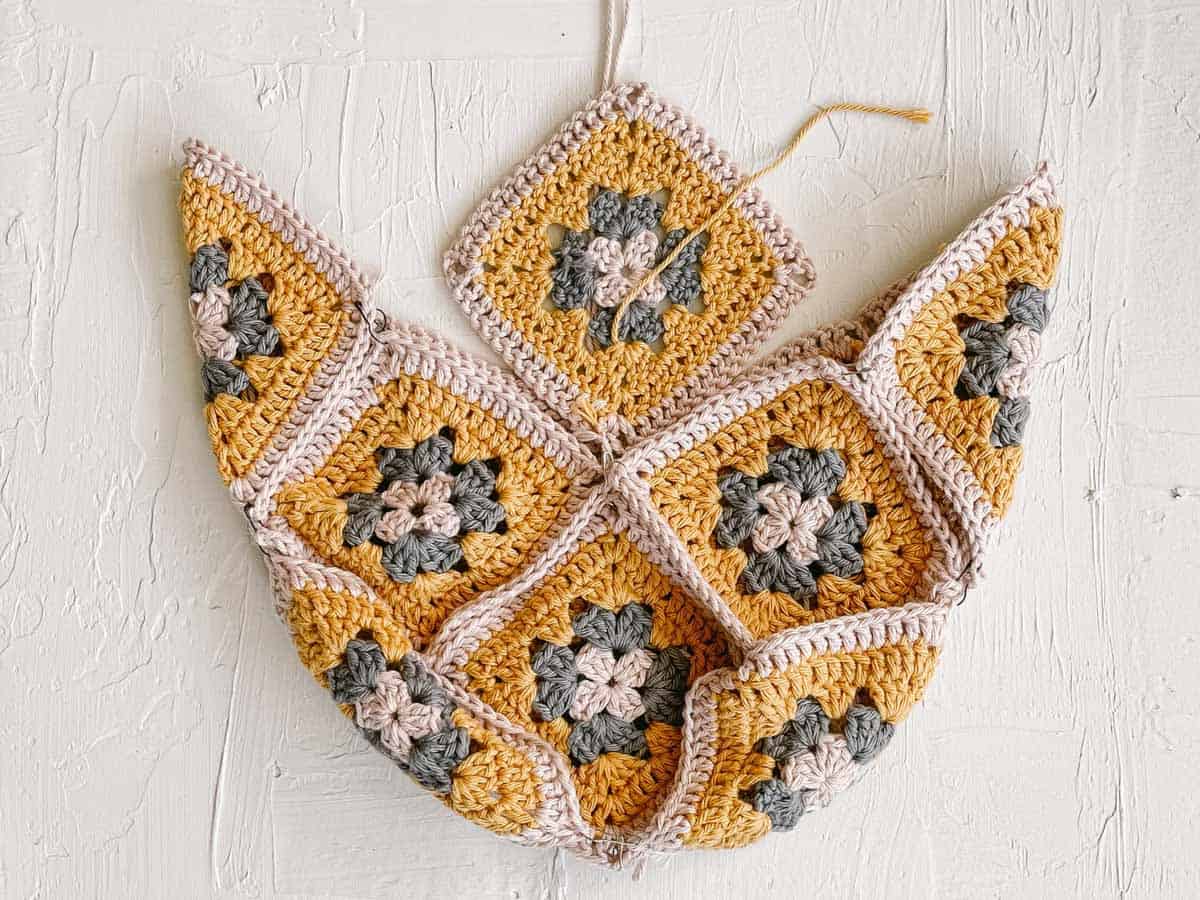 An overhead view of a crochet granny square purse in progress using Lion Brand Pima Cotton yarn.