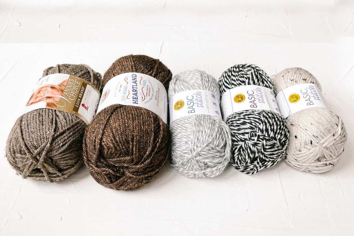 Five different worsted weight yarns laid out on a white background.