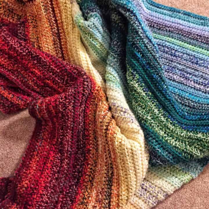 A weighted rainbow blanket scrunched on the floor.