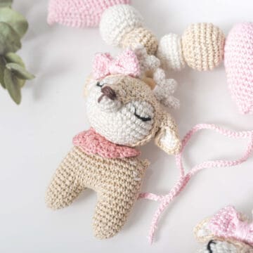 On a white background, a flat lay shot of a crochet deer amigurumi doll.