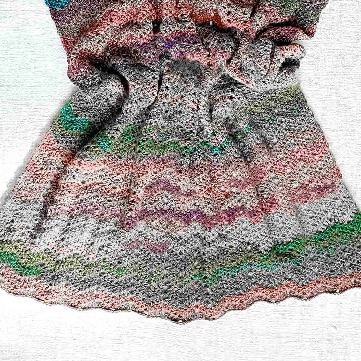 A crumpled crochet blanket on laid on a plain background.