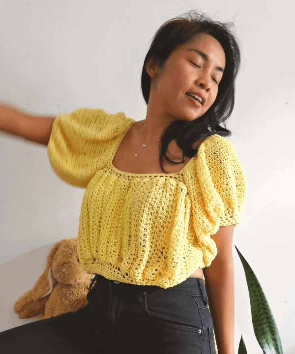 A woman wearing a puff sleeves crochet crop top.