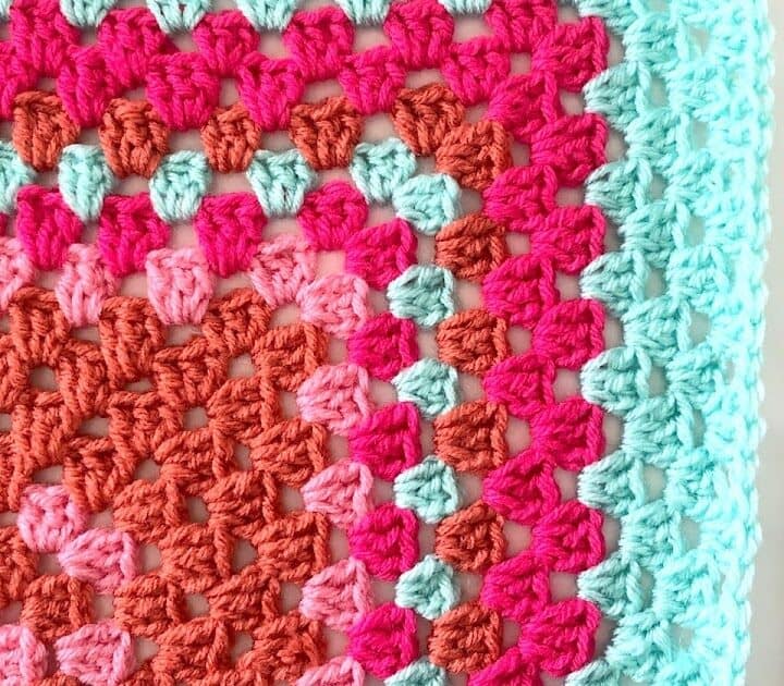 A corner temperature blanket with a crochet hook.