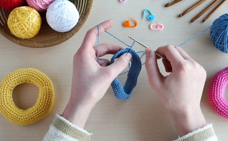 Hands crocheting an amigurumi circle.