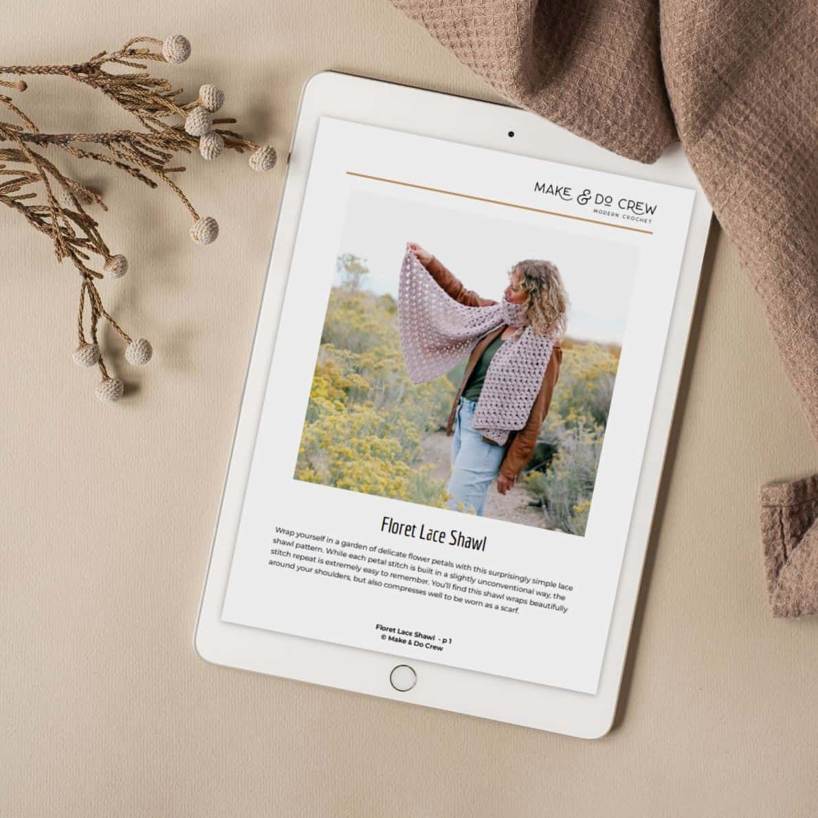 An iPad with the front page of the Floret Lace Scarf pattern displayed on it.