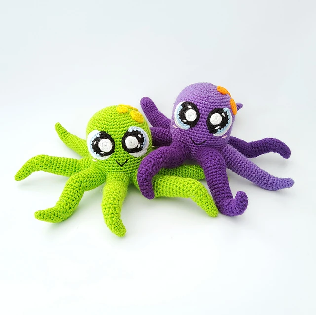 A green and purple colored octopus toy with orange and yellow details.