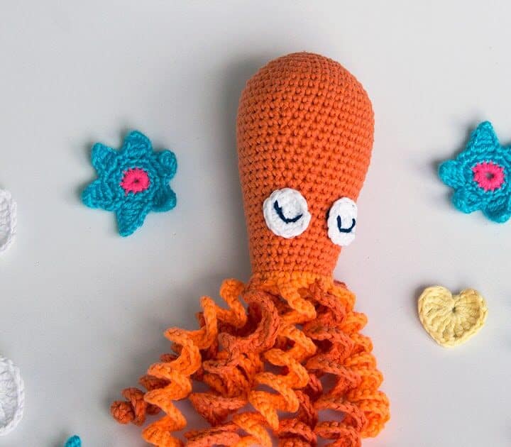 An orange octopus with mini hearts and stars around it.