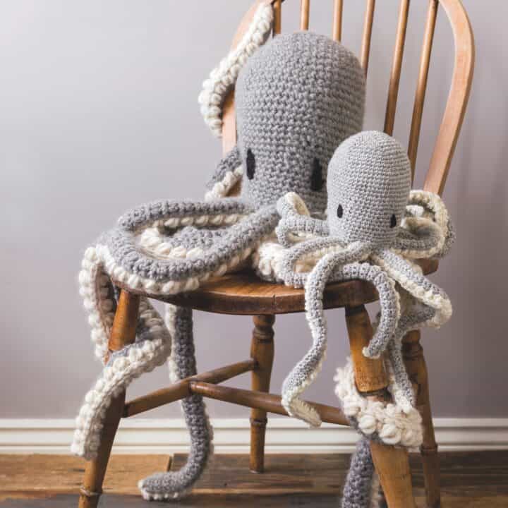 Two gray octopuses with long tentacles are on a wooden chair.