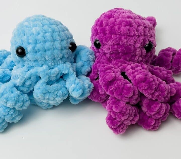 Two octopus toys colored blue and violet with black eyes.
