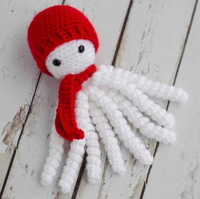 A white octopus with a red beanie and scarf.